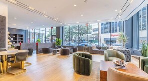 A modern lounge area with seating, a coffee table, and a view of the street outside. - Upscale 1BD| Downtown Dallas| Pool+Fitness Center (Dallas)