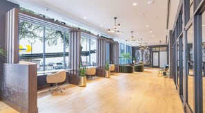 Ein modernes Interieur mit einer Rezeption, einer Sitzecke und großen Fenstern.