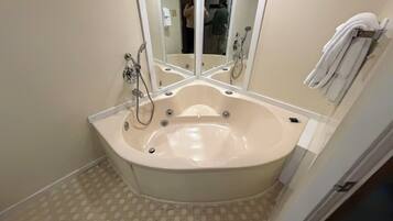 A bathroom with a freestanding bathtub, a large mirror, and a towel rack.