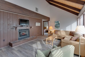 A living room with a fireplace, wooden walls, a sofa, and a lamp. - The Pedestals by CoolVacay (Basye)