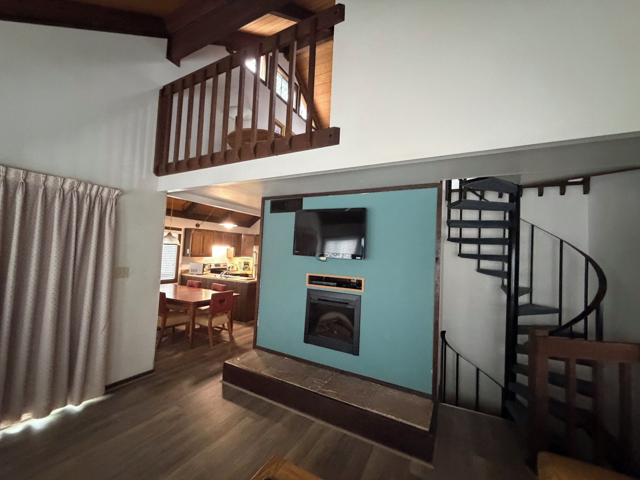 A staircase leading to a loft area with a television and fireplace.