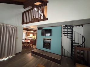 A staircase leading to a loft area with a television and fireplace. - The Pedestals by CoolVacay (Basye)