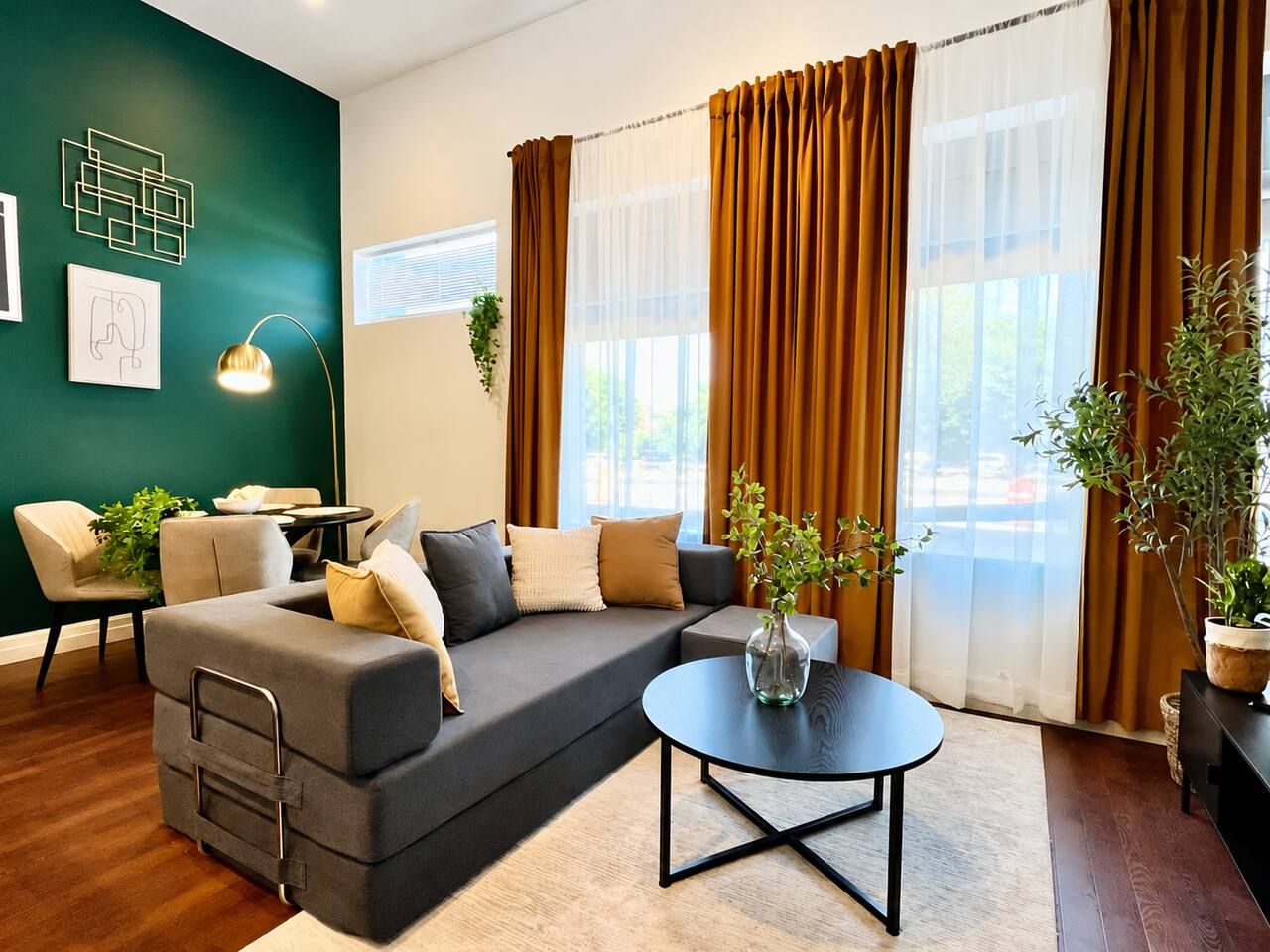 A modern living room with a sectional sofa, a round coffee table, and a dining area.