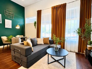 Ein modernes Wohnzimmer mit einer Eckcouch, einem runden Couchtisch und einem Essbereich.
