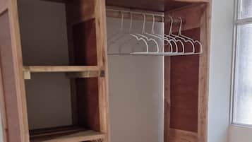 Un armadio in legno con ripiani multipli e un'asta appendiabiti.