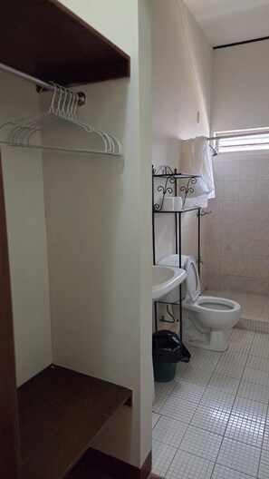 A small bathroom with a toilet, a sink, and a metal rack with a towel. - Casa Mundo Verde - Local Hostel (LEÓN)