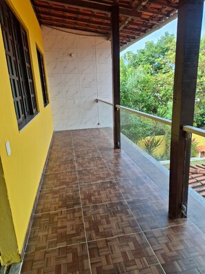 A covered balcony with a tiled floor, a railing, and a view of greenery. - New Listing (Vera Cruz)