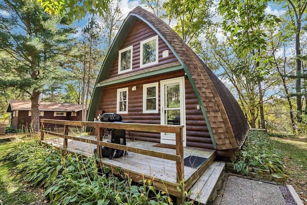A log cabin with a deck, a grill, and a small table. - Gem of an A-Frame; 10 minutes from Downtown Dells (Wisconsin Dells)
