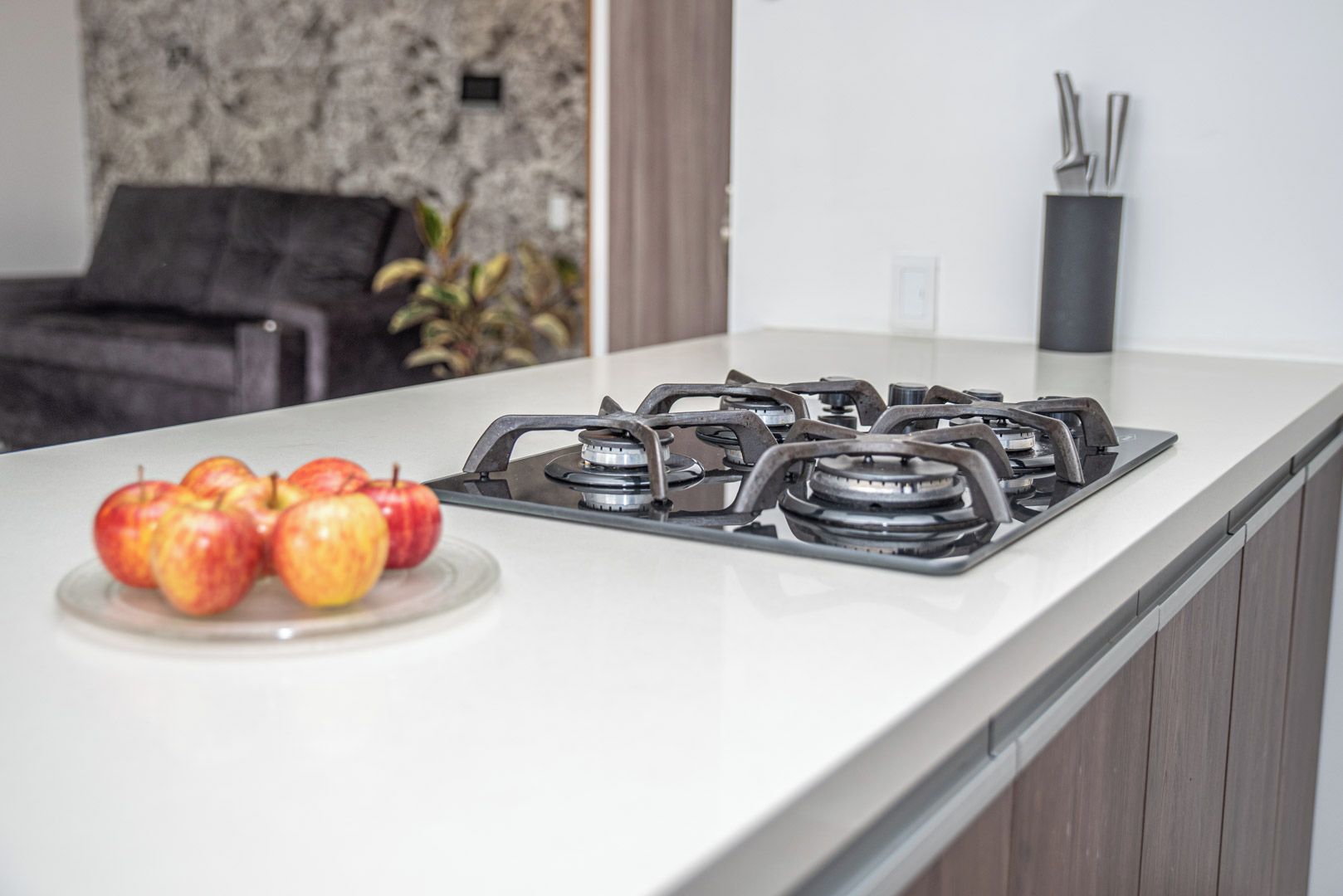 Una cucina con un fornello a gas e un piatto di mele.