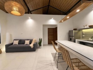 Ein modernes Interieur mit einer Couch, einer Essecke und einer Küche.