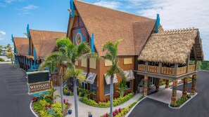 A resort with a thatched-roof structure, palm trees, and a sign reading "Westgate Cocoa Beach Resort."