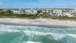 A beach with a view of the ocean and buildings in the background.
