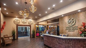 A reception area with a check-in counter, decorative wall art, and a sign for Westgate Cocoa Beach Resort.