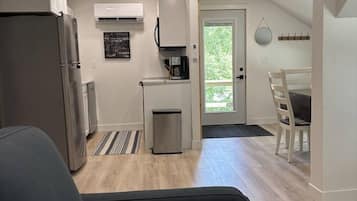 A compact living space with a kitchenette, a dining area, and a seating area.