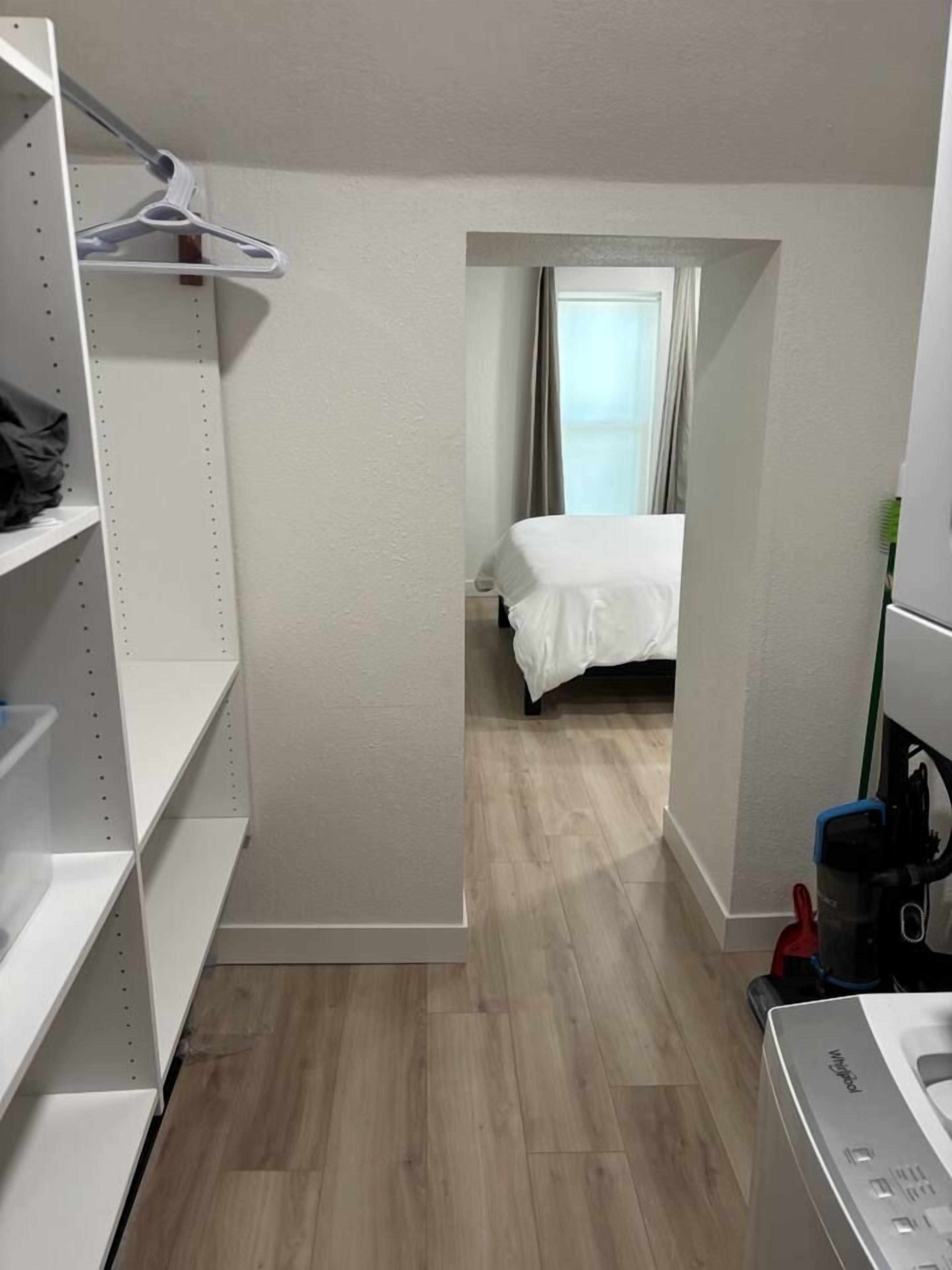 A hotel room with a bed, a wardrobe, and a washing machine.