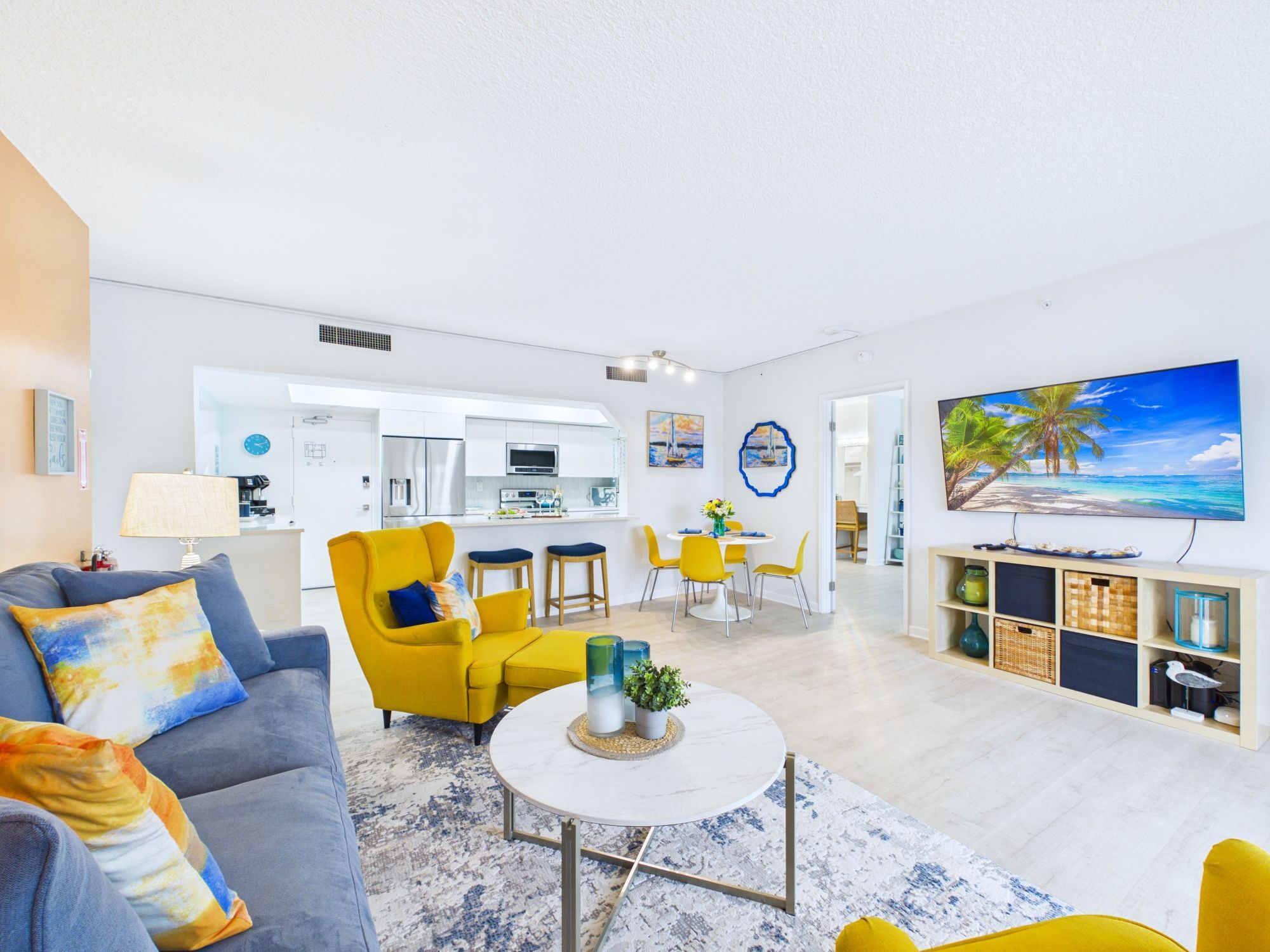 A modern living room with a sofa, yellow armchair, and a coffee table.
