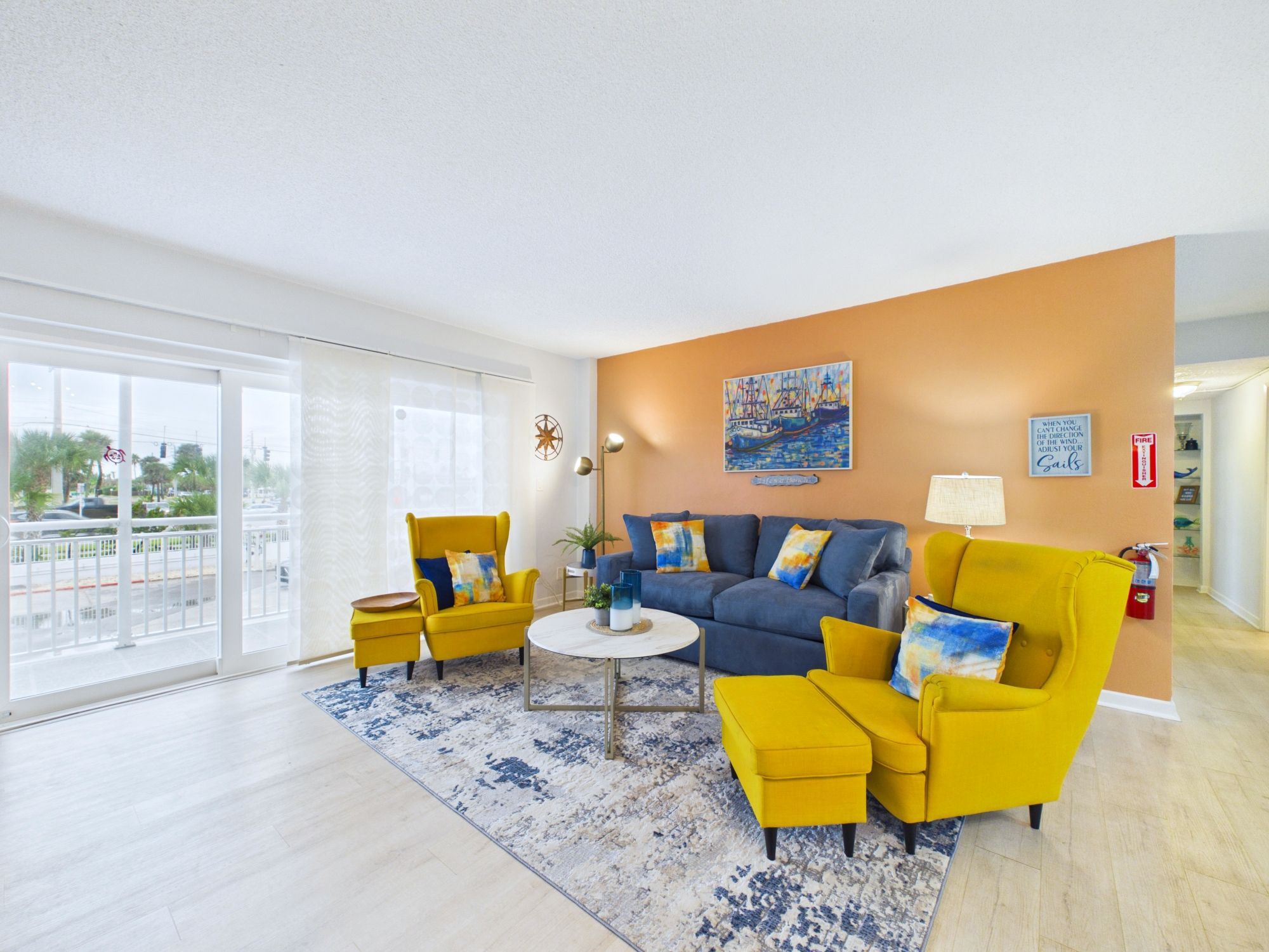 A modern living room with a sofa, armchairs, a coffee table, and a painting on the wall.