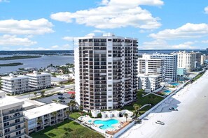 A high-rise hotel with multiple balconies, a swimming pool, and a beach view. - Oceanfront Condo | Balcony, Pool & Beach (Daytona Beach Shores)
