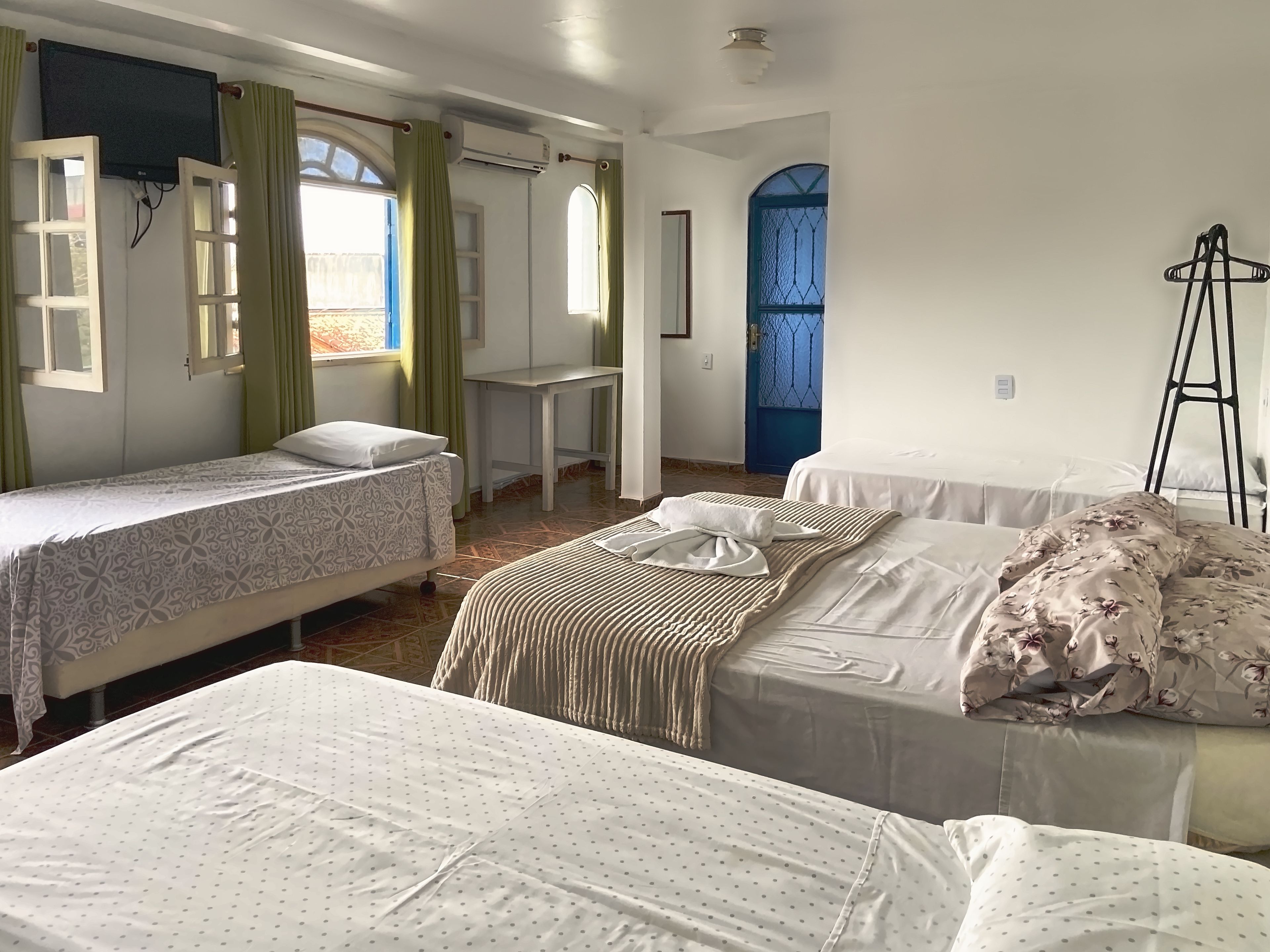 A room with two single beds, a small table, a chair, and a ladder.