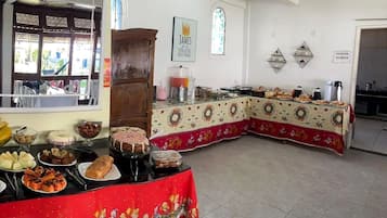 A dining area with a buffet setup, including various food items and a decorative tablecloth.