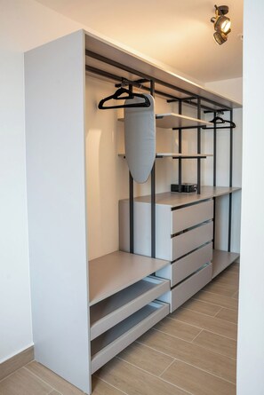 Ein moderner Kleiderschrank mit offenen Regalen, einer Kleiderstange und einem Schuhregal.