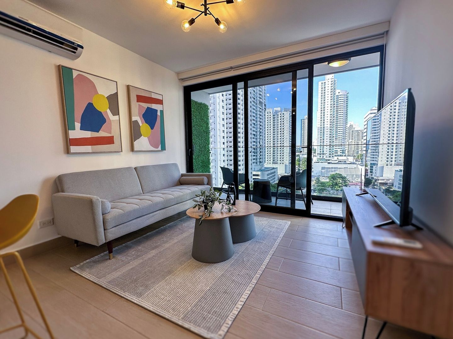 A modern living room with a grey sofa, a coffee table, and artwork on the wall.