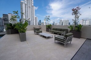 A rooftop terrace with outdoor furniture, potted plants, and a city skyline view. - Hotel-Style Room at The Hub, San Francisco (Panamá)