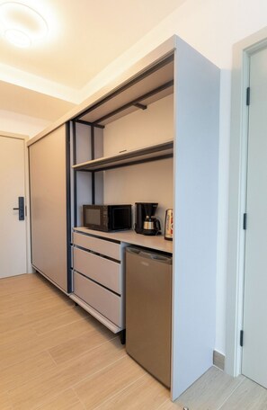 A compact kitchen with a microwave, coffee maker, and dishwasher. - Hotel-Style Room at The Hub, San Francisco (Panamá)