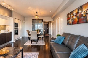 A modern apartment with a dining area, kitchen, and living room.