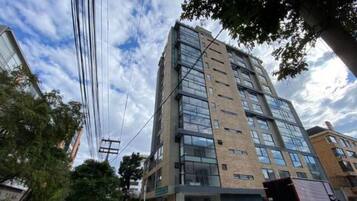 Un edificio de varios pisos con un diseño arquitectónico moderno, con amplias ventanas y techo plano.