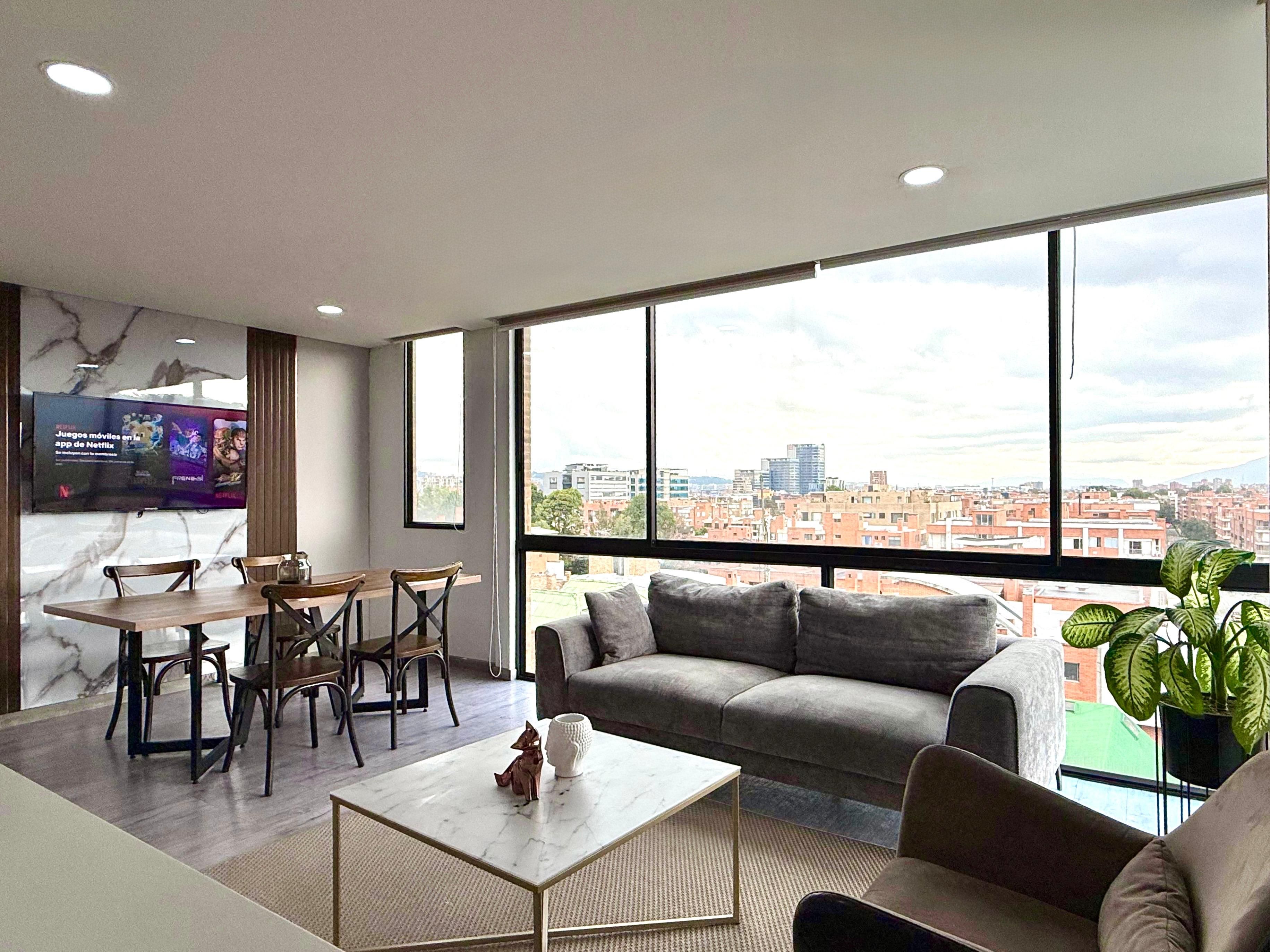 A modern living room with a sofa, coffee table, and dining area.