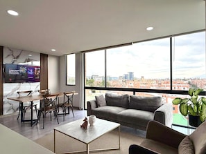 A modern living room with a sofa, coffee table, and dining area. - Espacioya By Mario Rental (Kappadocia) (Bogotá)