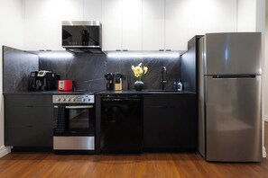 A modern kitchen with a built-in oven, microwave, and dishwasher, a stainless steel refrigerator, and a marble backsplash. - Steps to Yale! DWTN 2BR King Beds • Free Parking • Gym (New Haven)