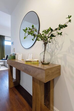 A wooden console table with a vase of greenery and books. - Steps to Yale! DWTN 2BR King Beds • Free Parking • Gym (New Haven)