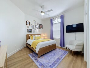 A bedroom with a bed, a ceiling fan, a TV, and a window with curtains. - Sundrop Oasis ☀️ | Remodeled 3-Bedroom Private Pool Villa Near Disney (Davenport)