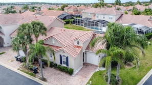 A residential area with houses featuring red-tiled roofs, palm trees, and a clear sky. - Sundrop Oasis ☀️ | Remodeled 3-Bedroom Private Pool Villa Near Disney (Davenport)