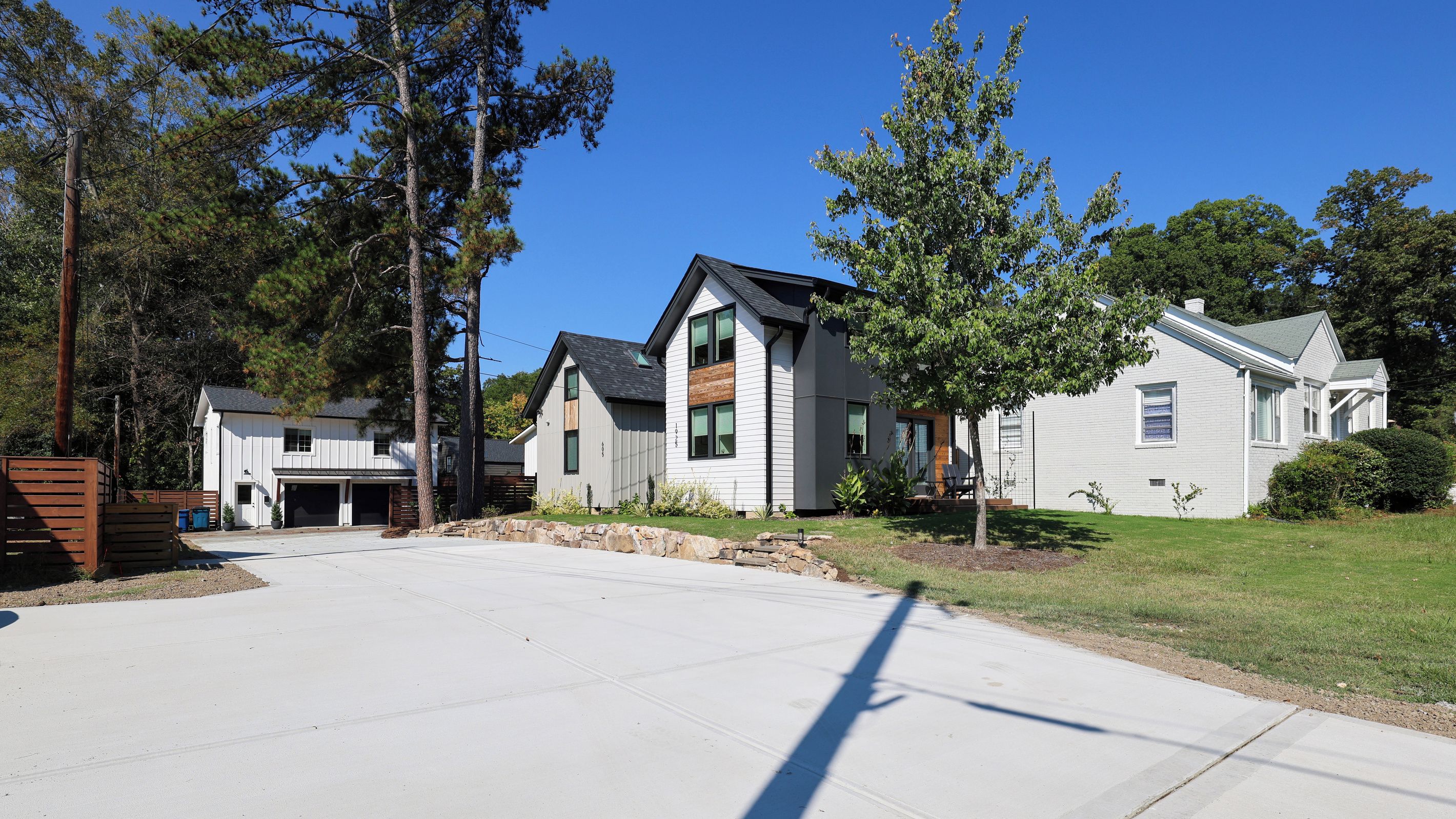A residential area with houses, a driveway, and a clear sky.