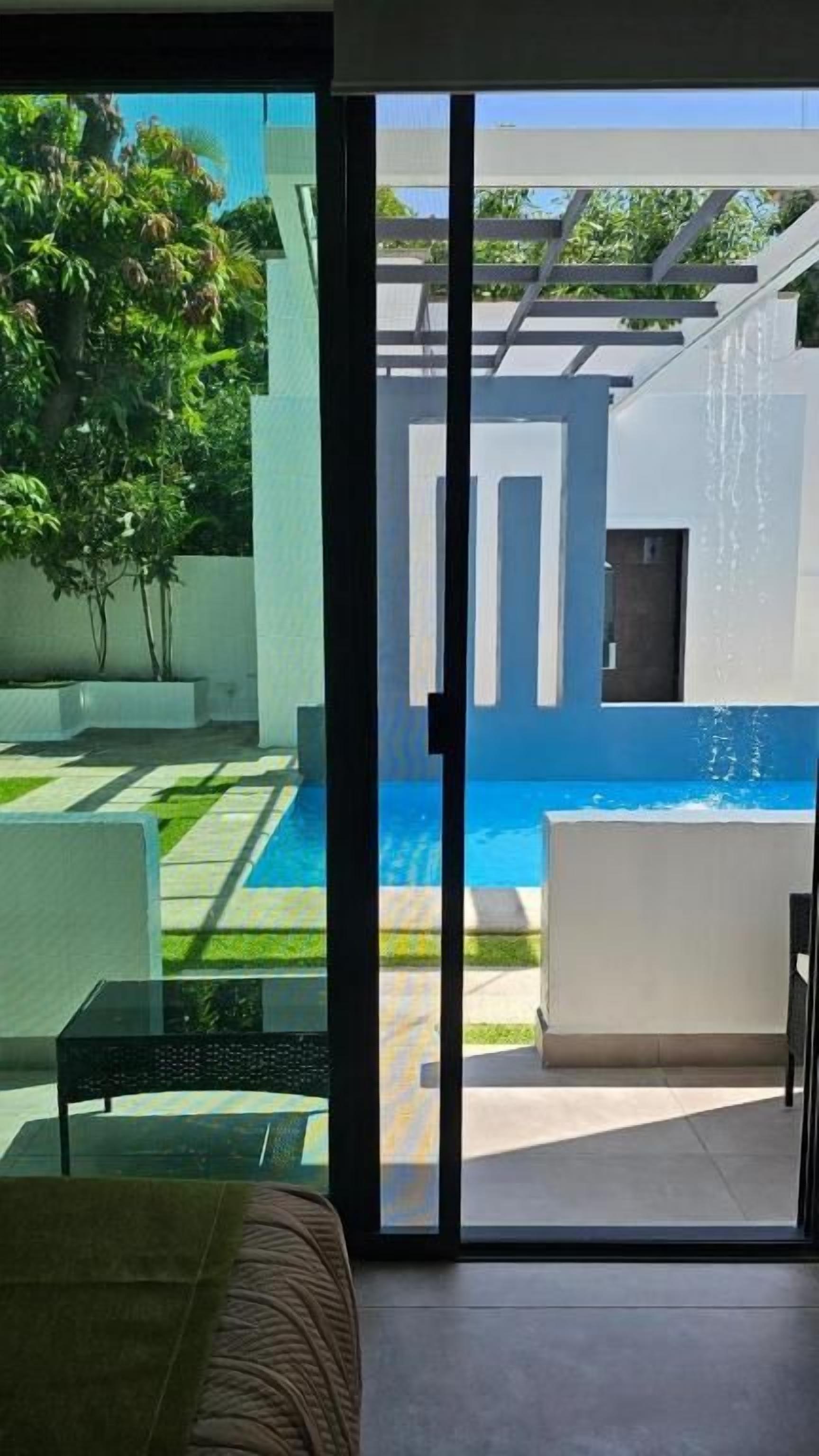 Habitació moderna amb una porta de vidre que dona a una zona de piscina.