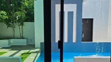 A modern room with a glass door leading to a pool area.
