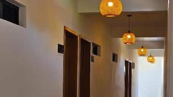 A hallway with doors, hanging light fixtures, and tiled flooring.
