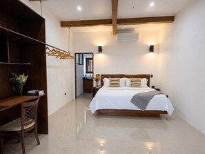 A bedroom with a wooden bed, bedside tables, a desk, and a chair. - Octagon Villa by Pura Villas (Bahía Ballena)