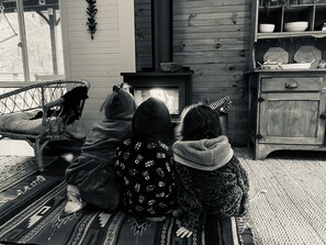 Une pièce avec une cheminée, un meuble en bois et un tapis à motifs.