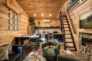 Ein gemütliches Blockhaus-Interieur mit Essbereich, Küche und Kamin.