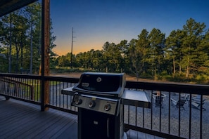 A grill on a wooden deck with a view of trees and a clear sky. - Broken Bow Bliss · Private Heated Pool, Hot Tub & Arcade Game Room | Sleeps 12 (Broken Bow)