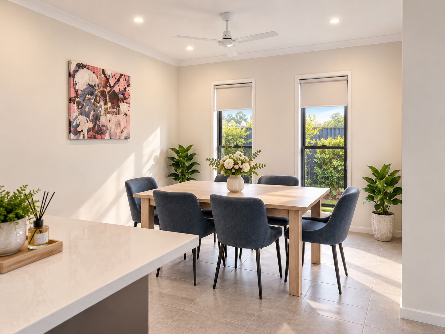 Un espace repas moderne avec une table en bois, six chaises et deux plantes en pot.