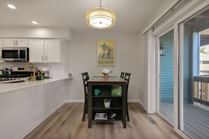 A modern kitchen with white cabinets, a stainless steel microwave, and a black stove. - Luxury Legacy Retreat | Sleeps 10 | South Bend (South Bend)