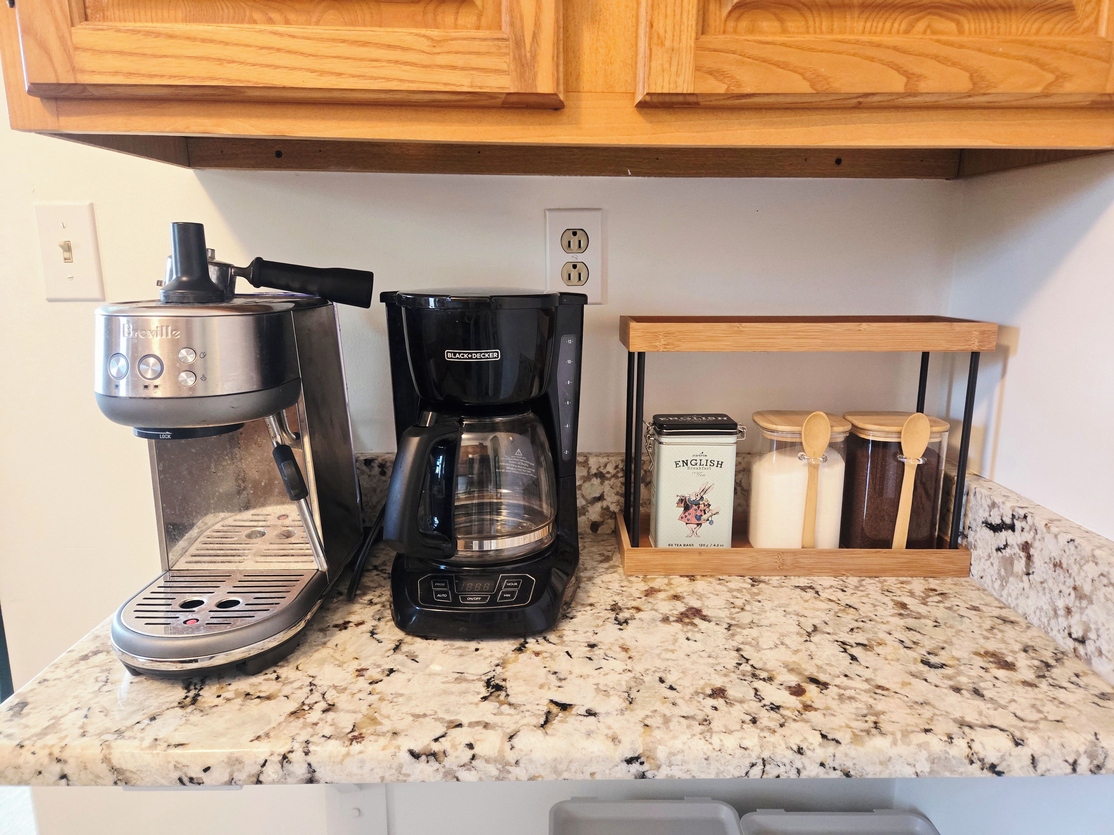 A kitchen counter with a coffee maker, a scale, and a spice rack.