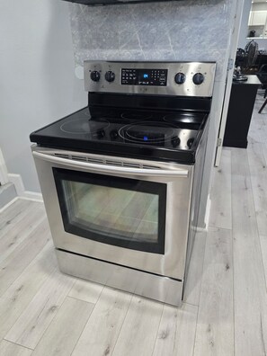 A stainless steel oven with a digital control panel and a glass door.