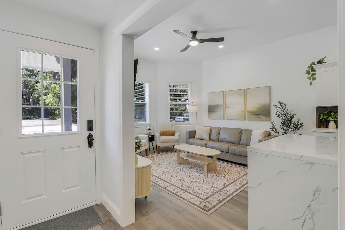 A modern living room with a sofa, coffee table, and a ceiling fan.