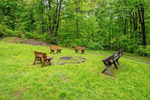 A natural setting with a fire pit and wooden benches. - Peaceful | Mountaintop Getaway | Solar Power (Springwater)